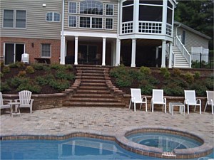 New paver pool deck with stairs leading to paver patio in back of house with all new landscaping